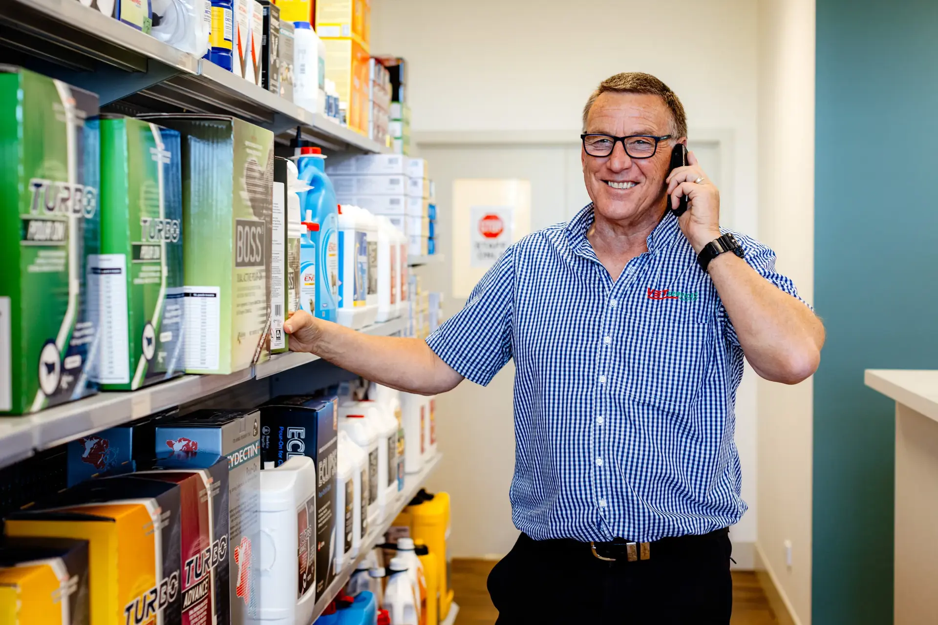 Brendan James, General Manager of Vet Services, speaks on the phone while standing in front of shelves stocked with animal care products. The longstanding relationship with Now has supported the growth and communication needs of Vet Services' four clinics across Hawkes Bay.
