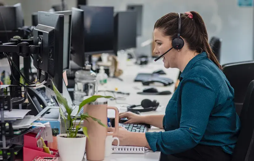 Call centre agent using a computer and headset, representing Now Reach's ACD call centre solution with features like skill-based routing and automatic callbacks